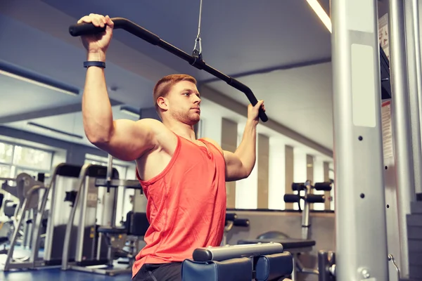 Uomo flessione muscoli sulla macchina via cavo palestra — Foto Stock