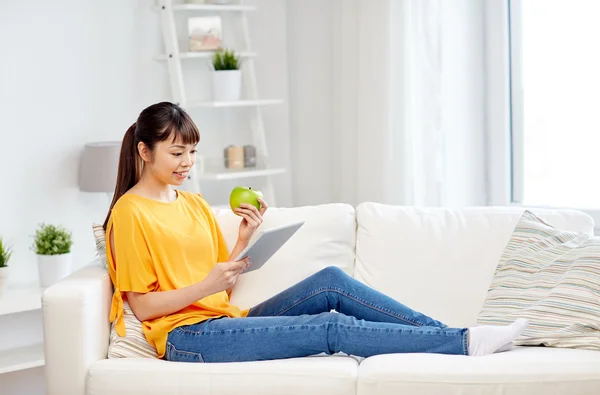 Feliz mujer asiática con tableta pc y manzana en casa — Foto de Stock