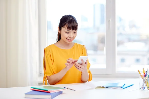 Gelukkig jonge vrouw student met smartphone thuis — Stockfoto