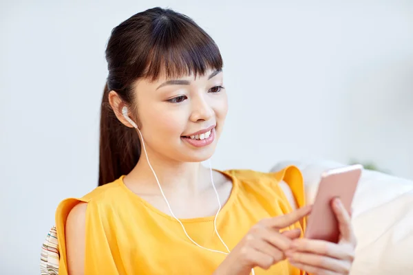 Mujer asiática feliz con teléfono inteligente y auriculares —  Fotos de Stock