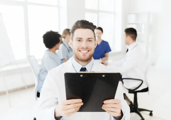 Médico feliz com tablet pc sobre a equipe na clínica — Fotografia de Stock