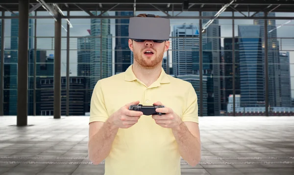 Homem em fone de ouvido de realidade virtual com gamepad — Fotografia de Stock
