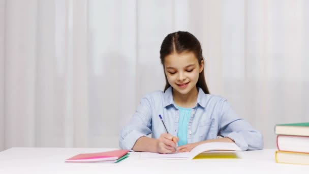 Chica de la escuela feliz con libros y bloc de notas en casa — Vídeos de Stock