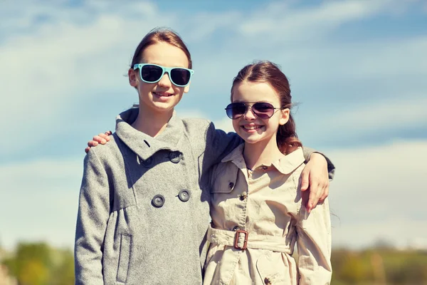 Fröhliche kleine Mädchen mit Sonnenbrille, die sich im Freien umarmen — Stockfoto