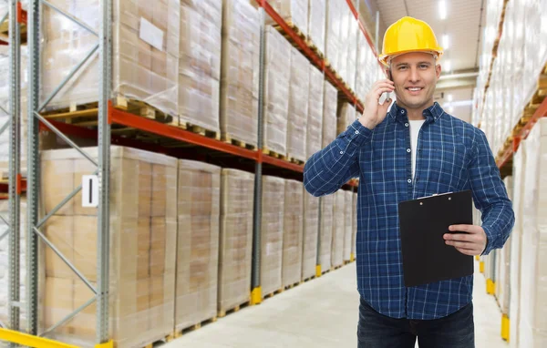 Man with clipboard and smartphone at warehouse — Stock Photo, Image