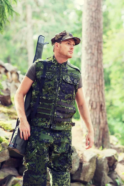 Jovem soldado ou caçador com arma na floresta — Fotografia de Stock