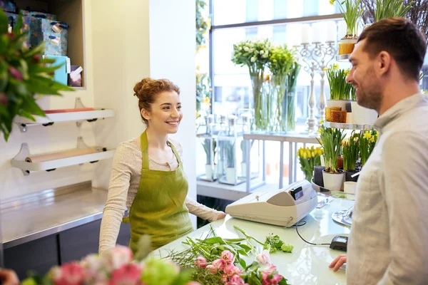Sorridente florista mulher e homem na loja de flores — Fotografia de Stock