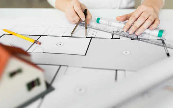 Close up of hands with compass measuring blueprint — Stock Photo, Image