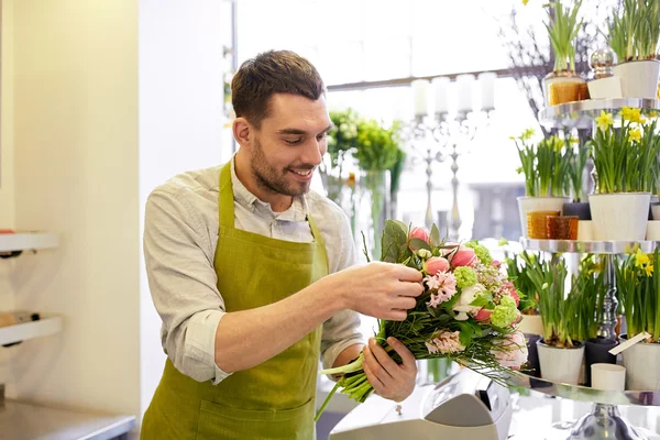 Sorridente florista homem fazendo monte na loja de flores — Fotografia de Stock