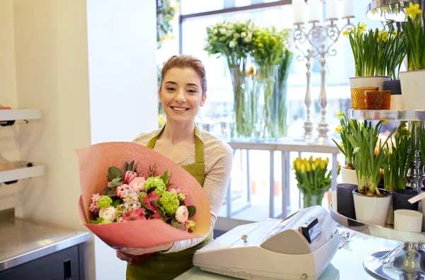 Sonriente florista mujer con ramo en floristería — Foto de Stock