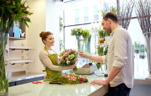 Sorridente florista mulher e homem na loja de flores — Fotografia de Stock