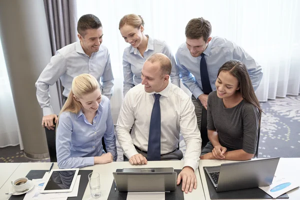 Lächelnde Geschäftsleute mit Laptop im Büro — Stockfoto