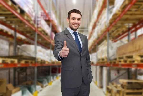 Happy man at warehouse showing thumbs up gesture — Stock Photo, Image