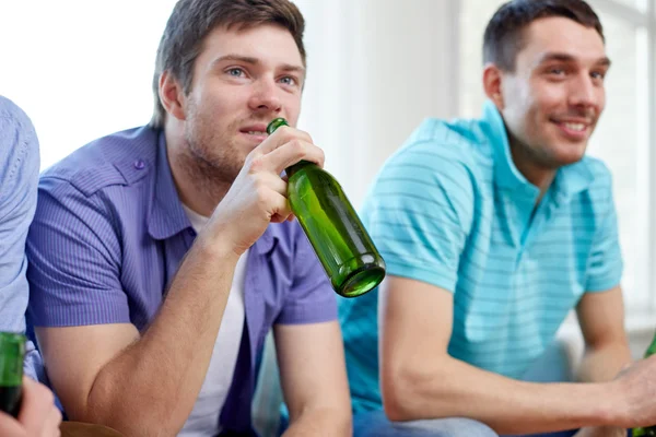 Happy male friends drinking beer at home — 스톡 사진