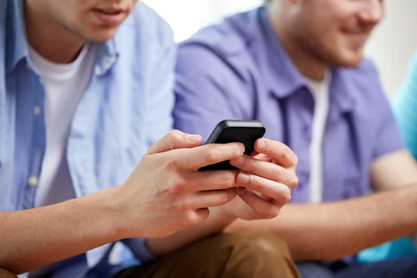 Närbild av glada vänner med smartphones hemma — Stockfoto