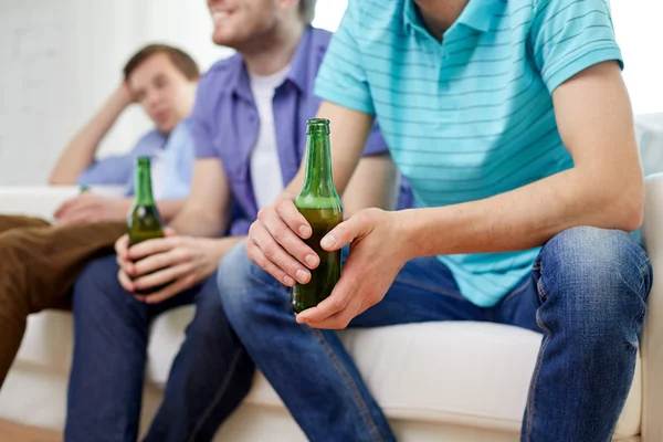 Happy male friends drinking beer at home — ストック写真