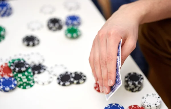 Close up of male hand with playing cards and chips — Stock Photo, Image