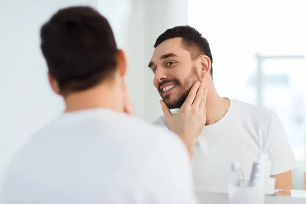 Felice giovane cercando di specchio a casa bagno — Foto Stock