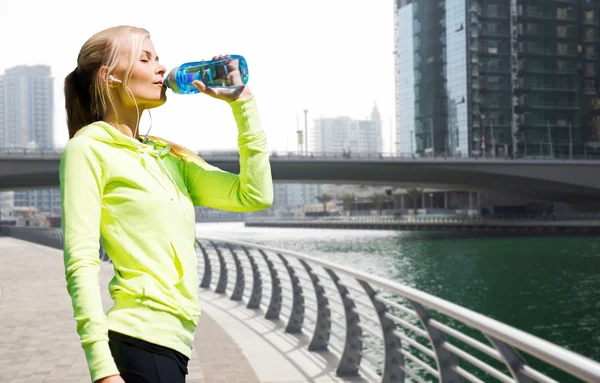 Mujer beber agua después de hacer deportes al aire libre — Foto de Stock