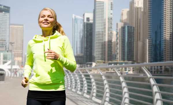 Glückliche junge Frau joggt im Freien — Stockfoto