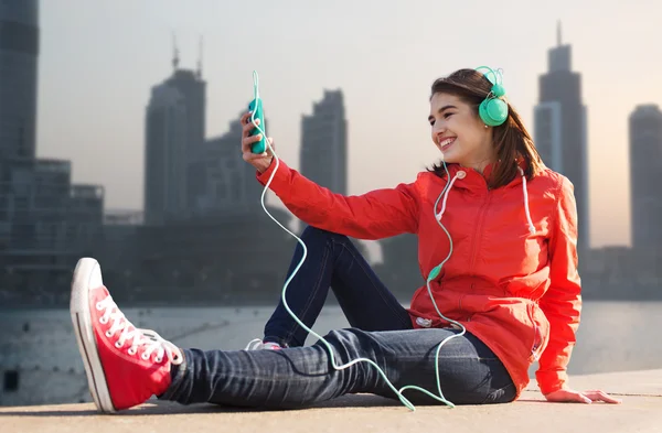 Jeune femme heureuse avec smartphone et écouteurs — Photo