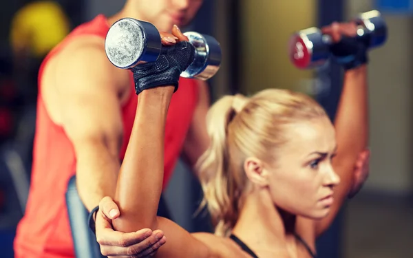 Uomo e donna con manubri in palestra — Foto Stock