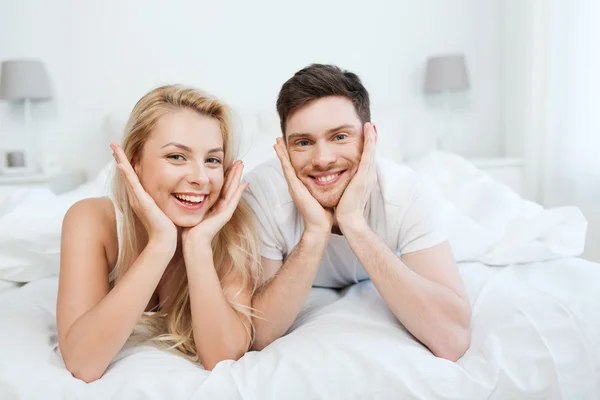 Casal feliz deitado na cama em casa — Fotografia de Stock