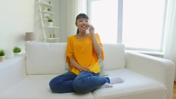 Feliz asiático mujer llamando en smartphone en casa — Vídeo de stock