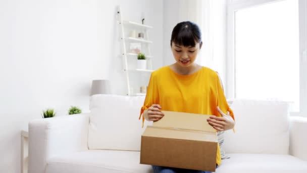 Happy asian young woman with parcel box at home — Stock Video