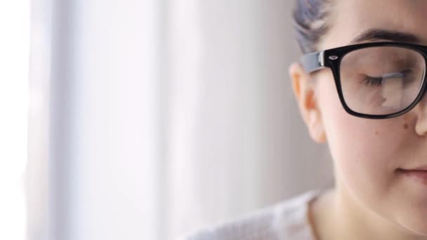 Ung kvinna i glasögon med smartphone hemma — Stockvideo