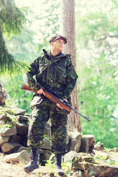 Joven soldado o cazador con pistola en el bosque — Foto de Stock