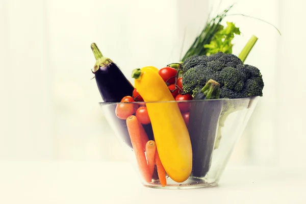 Närbild på mogen grönsaker i glasskål på bord — Stockfoto