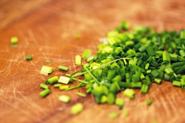 Close-up de cebola picada em tábua de corte de madeira — Fotografia de Stock