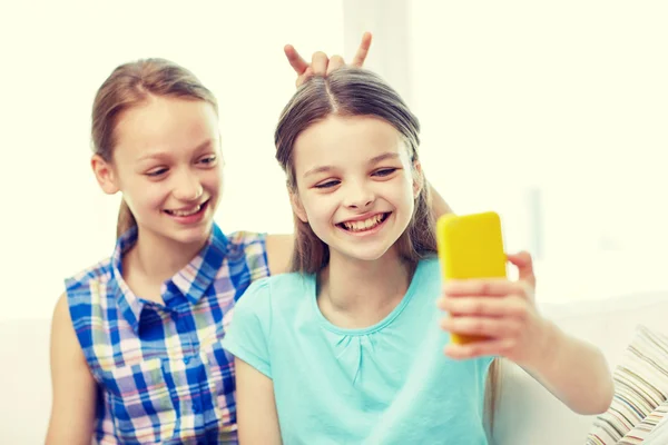 Chicas felices con teléfono inteligente tomar selfie en casa — Foto de Stock
