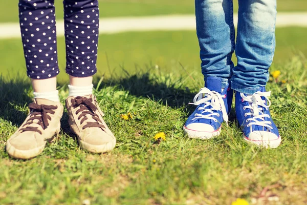Close up of kids legs in shoes on grass outdoors Stockbild