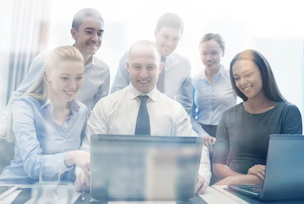 Smiling business people with laptop in office — Stock Photo, Image