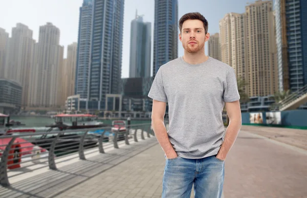 Junger Mann in grauem T-Shirt und Jeans über der Stadt — Stockfoto
