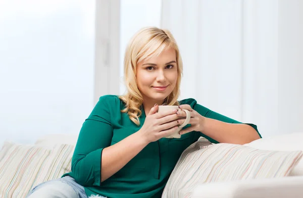 Gelukkige vrouw met een kopje thee of koffie thuis — Stockfoto