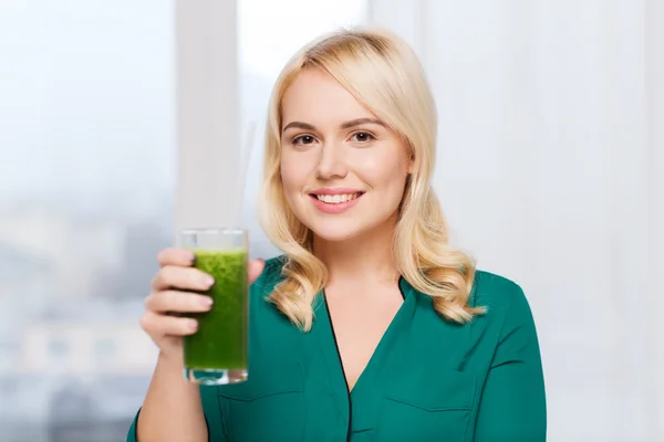 Leende kvinna dricka juice eller smoothie hemma — Stockfoto