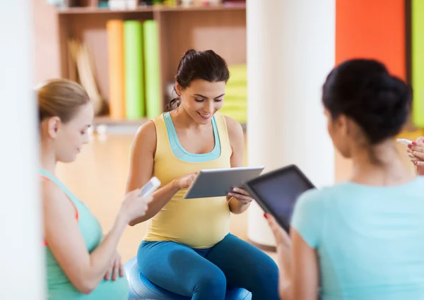 Mujeres embarazadas felices con gadgets en el gimnasio — Foto de Stock
