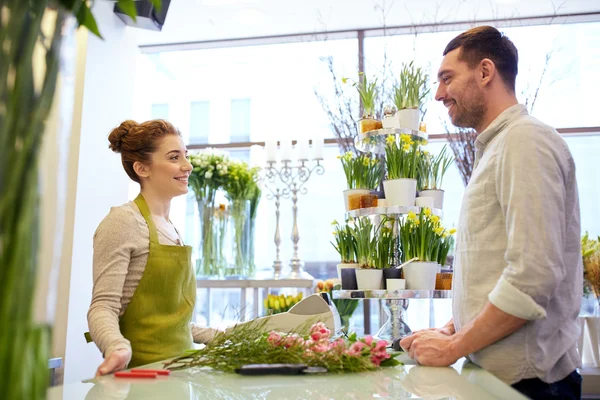 Fiorista sorridente donna e uomo al negozio di fiori Immagine Stock