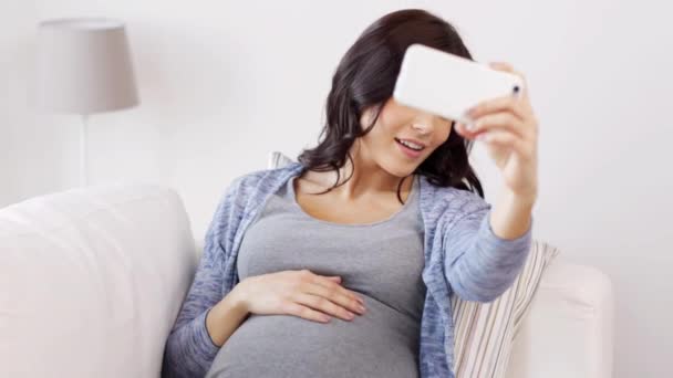 Pregnant woman taking selfy by smartphone at home — Stock Video