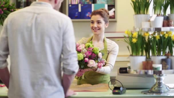 Florista mulher com flores e homem na loja de flores — Vídeo de Stock