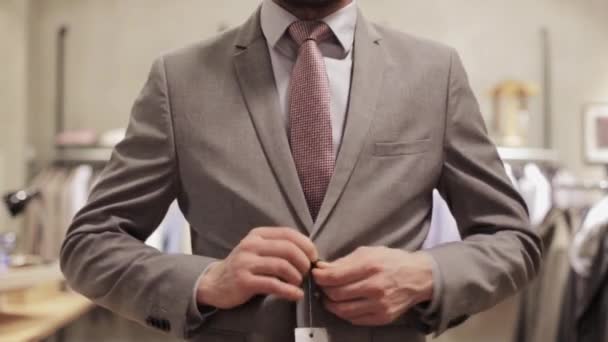 Мужчина делает селфи на смартфоне в магазине одежды — стоковое видео