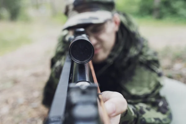 Close up of soldier or hunter with gun in forest — Stock Photo, Image