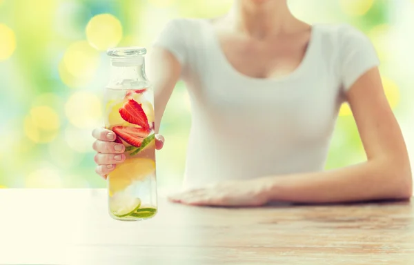 Közelkép a nő gyümölcs vízzel üveg — Stock Fotó