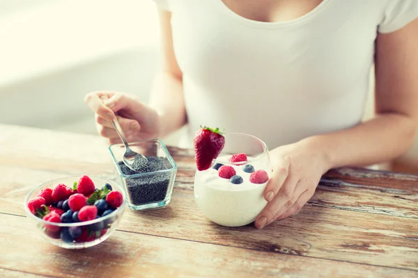 Крупним планом жіночі руки з йогуртом і ягодами — стокове фото