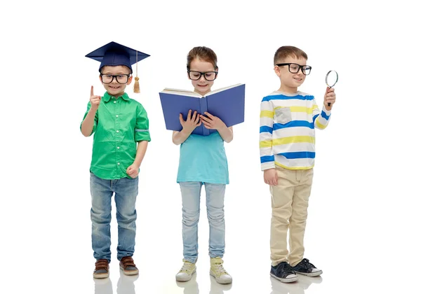 Діти в окулярах з книгою, лінзою та капелюхом холостяка — стокове фото