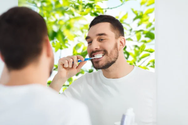 Homme avec brosse à dents nettoyage des dents à la salle de bain — Photo