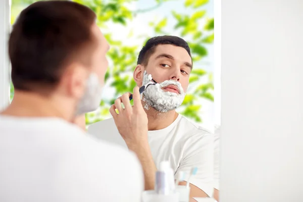 Mann rasiert Bart mit Rasierklinge im Badezimmer — Stockfoto